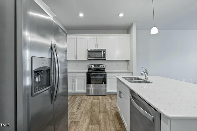 kitchen with white cabinetry, stainless steel appliances, sink, and pendant lighting