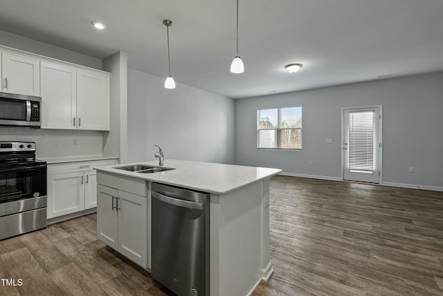 kitchen with appliances with stainless steel finishes, white cabinetry, sink, dark hardwood / wood-style flooring, and hanging light fixtures