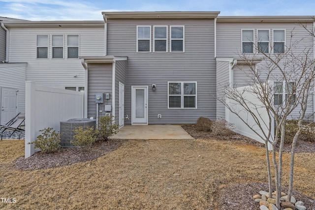 back of property with a patio area, central air condition unit, and a lawn