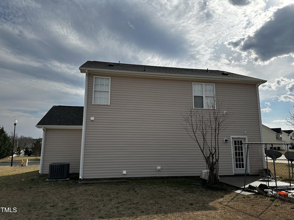 view of side of home featuring a patio, a yard, cooling unit, and fence