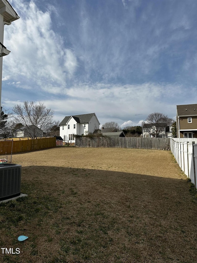 view of yard with central air condition unit and a fenced backyard