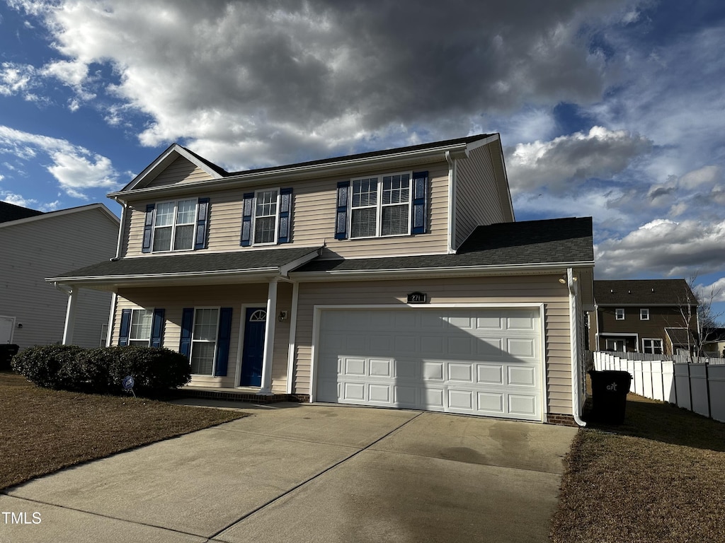 view of front of home with a garage, fence, and concrete driveway