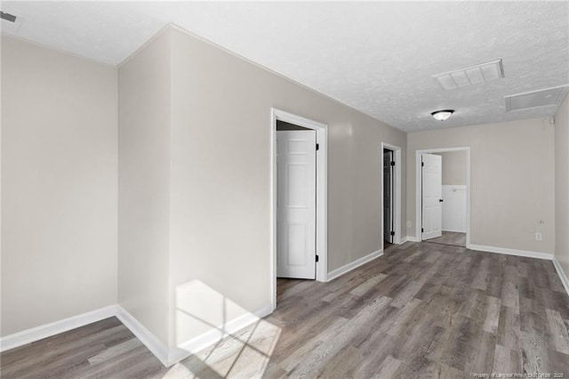 empty room with hardwood / wood-style floors and a textured ceiling