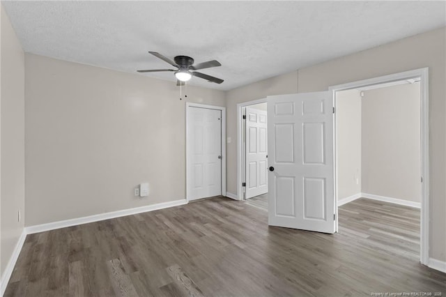 unfurnished bedroom featuring wood-type flooring, ceiling fan, and a textured ceiling