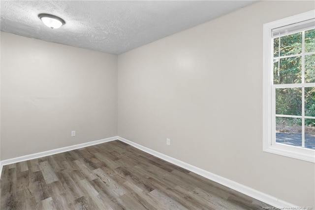 unfurnished room featuring hardwood / wood-style flooring and a textured ceiling