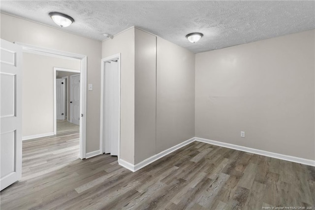 spare room with dark hardwood / wood-style floors and a textured ceiling