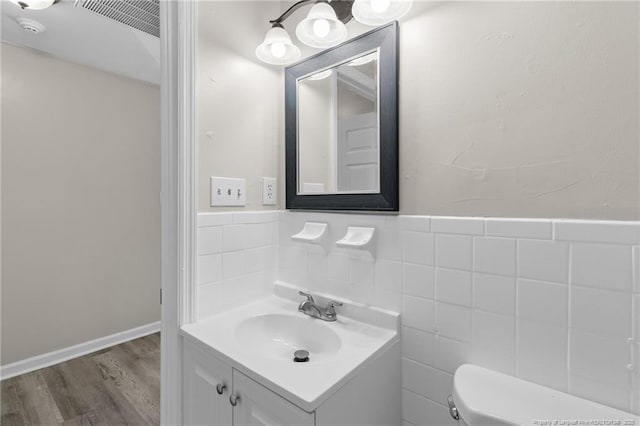 bathroom featuring vanity, wood-type flooring, tile walls, and toilet