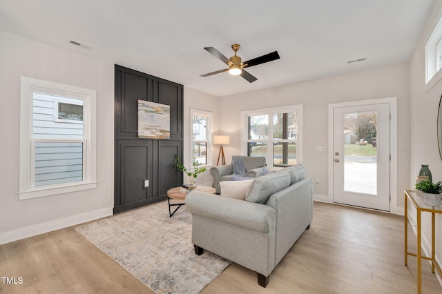 living room featuring light hardwood / wood-style flooring and ceiling fan