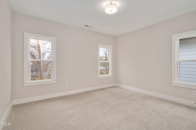 spare room featuring light carpet