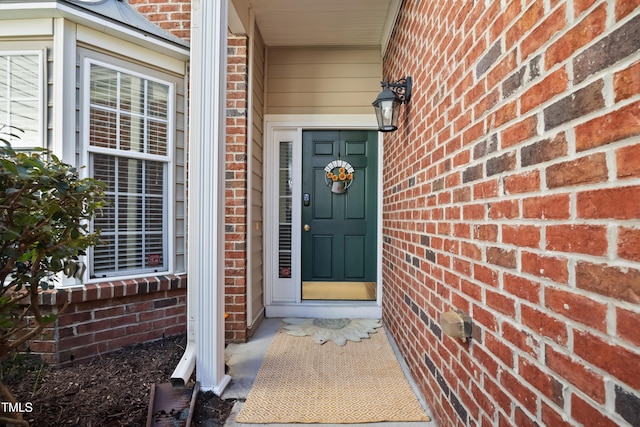 entrance to property featuring brick siding