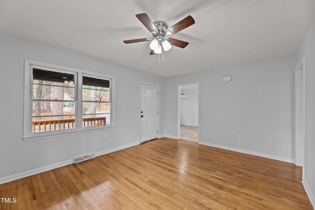 spare room featuring ceiling fan, light hardwood / wood-style flooring, and a textured ceiling