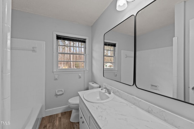 full bathroom featuring vanity, toilet, wood-type flooring, and a textured ceiling