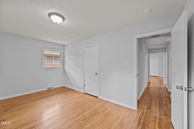 unfurnished bedroom featuring a textured ceiling and light wood-type flooring