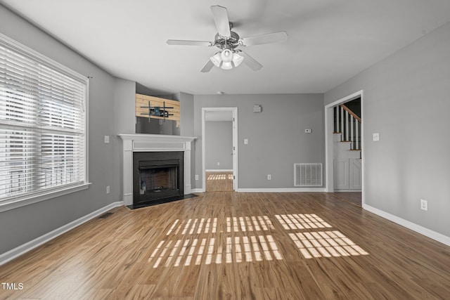 unfurnished living room with wood-type flooring and ceiling fan