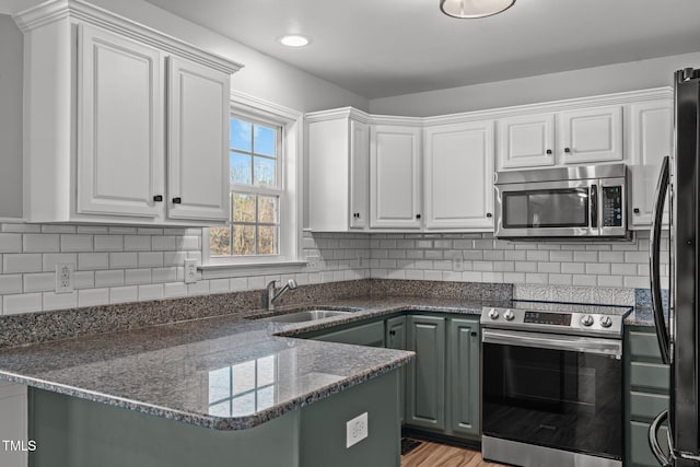 kitchen featuring white cabinetry, stainless steel appliances, and kitchen peninsula