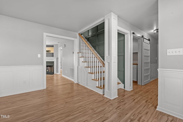 stairs with hardwood / wood-style flooring and a barn door