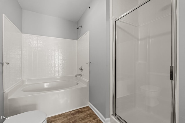 bathroom featuring hardwood / wood-style flooring, toilet, and separate shower and tub