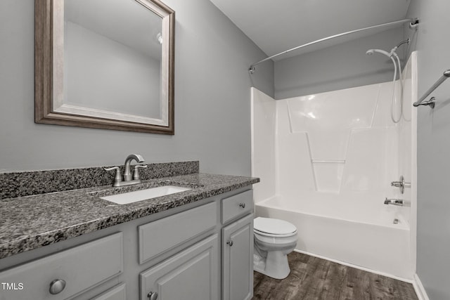 full bathroom featuring hardwood / wood-style flooring, shower / washtub combination, toilet, and vanity