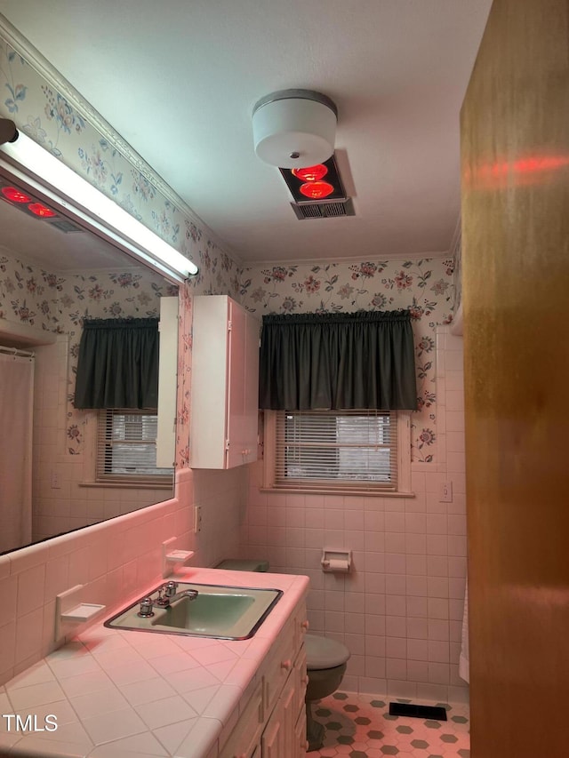 bathroom with vanity, tile walls, and toilet