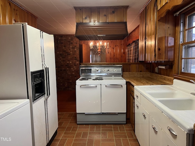 kitchen featuring extractor fan, washer / clothes dryer, sink, white appliances, and an inviting chandelier