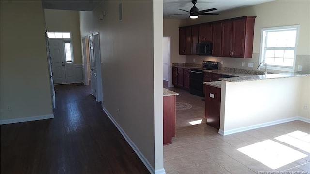 3922 Tasha Dr, Hope Mills, NC 28348 - kitchen with ceiling fan, a healthy amount of sunlight, light stone counters, and black / electric stove