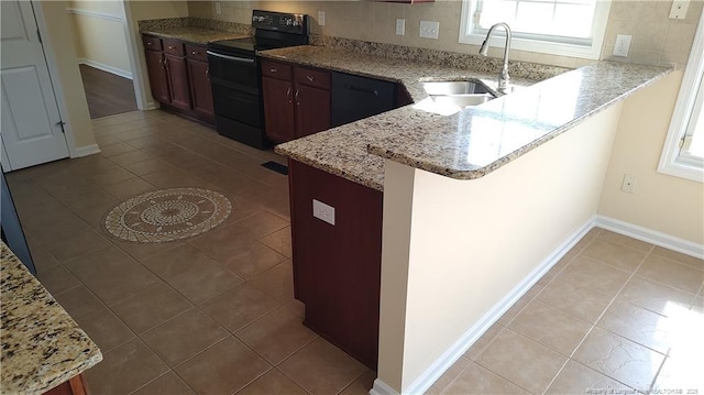 3922 Tasha Dr, Hope Mills, NC 28348 - kitchen with sink, light tile patterned floors, electric range, light stone countertops, and kitchen peninsula