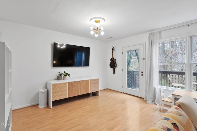 living room featuring an inviting chandelier and light hardwood / wood-style flooring