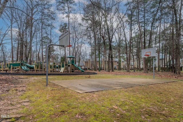 view of jungle gym with basketball court and a lawn