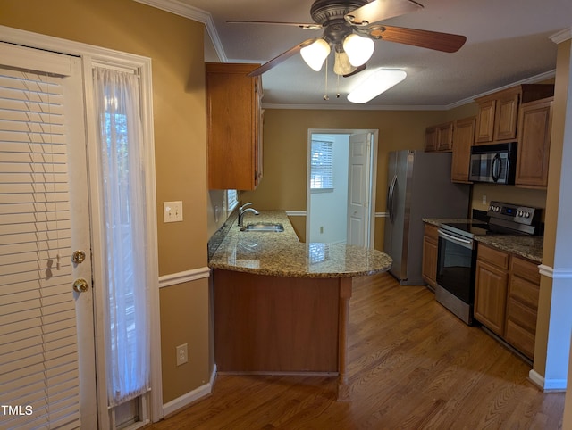 kitchen featuring sink, crown molding, stainless steel appliances, kitchen peninsula, and light wood-type flooring