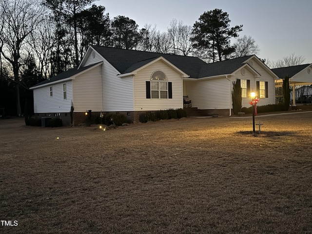view of front facade with crawl space and a shingled roof