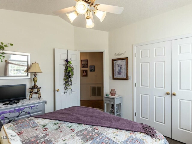 bedroom featuring ceiling fan, a textured ceiling, a closet, visible vents, and lofted ceiling