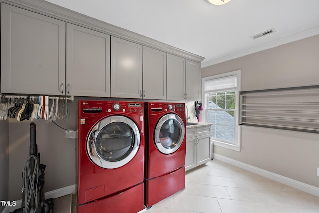 laundry room with washer and dryer, ornamental molding, and cabinets