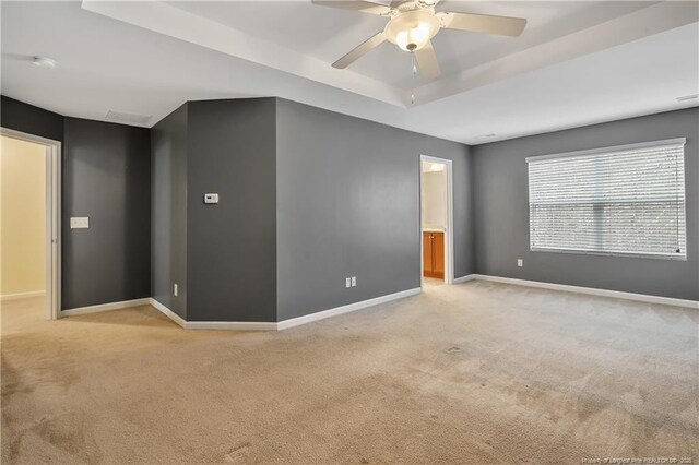 323 River Oak St, Spring Lake, NC 28390 - spare room with light colored carpet, baseboards, a ceiling fan, and a tray ceiling