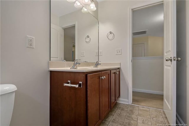 323 River Oak St, Spring Lake, NC 28390 - bathroom featuring toilet, vanity, stone finish floor, visible vents, and baseboards