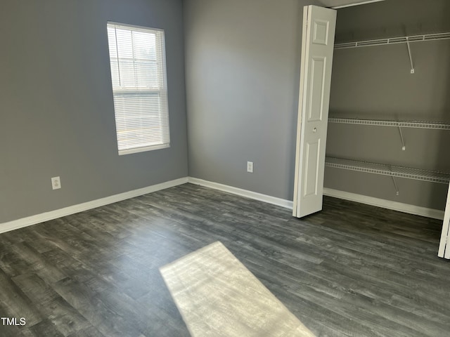 unfurnished bedroom with dark hardwood / wood-style flooring and a closet