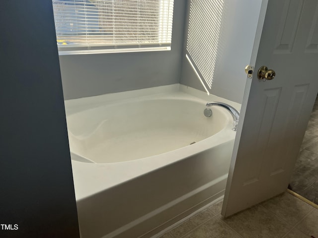 bathroom with a bathing tub and tile patterned flooring