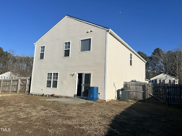 rear view of property featuring a patio, central AC unit, and a lawn