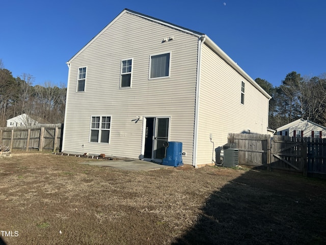 rear view of property with a yard, a patio, and central air condition unit