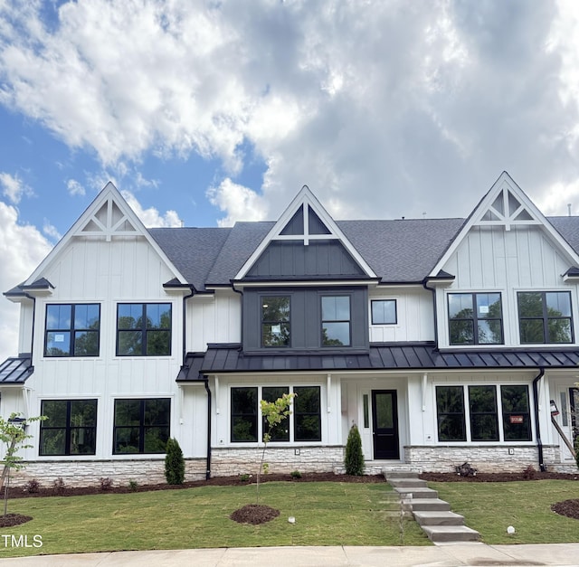view of front of home with a front lawn, roof with shingles, metal roof, and a standing seam roof