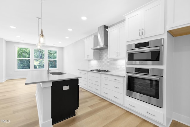 905 Myers Point Dr, Morrisville, NC 27560 - kitchen featuring wall chimney range hood, stainless steel appliances, light wood finished floors, light countertops, and recessed lighting