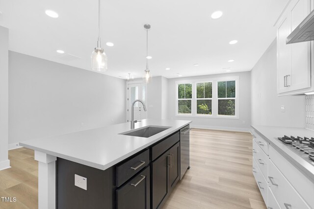 905 Myers Point Dr, Morrisville, NC 27560 - kitchen featuring light countertops, appliances with stainless steel finishes, wall chimney exhaust hood, white cabinetry, and a kitchen island with sink