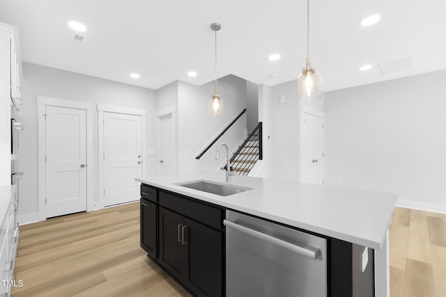 905 Myers Point Dr, Morrisville, NC 27560 - kitchen featuring stainless steel dishwasher, dark cabinets, a kitchen island with sink, light countertops, and light wood-style floors