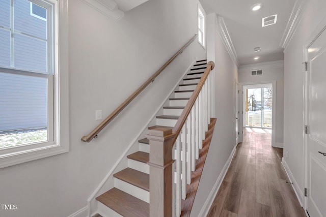stairs featuring wood-type flooring and ornamental molding