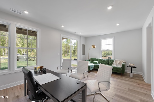 office with light hardwood / wood-style floors and electric panel
