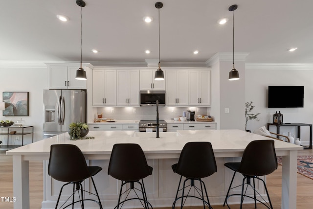 kitchen featuring a spacious island, stainless steel appliances, decorative light fixtures, and light stone countertops
