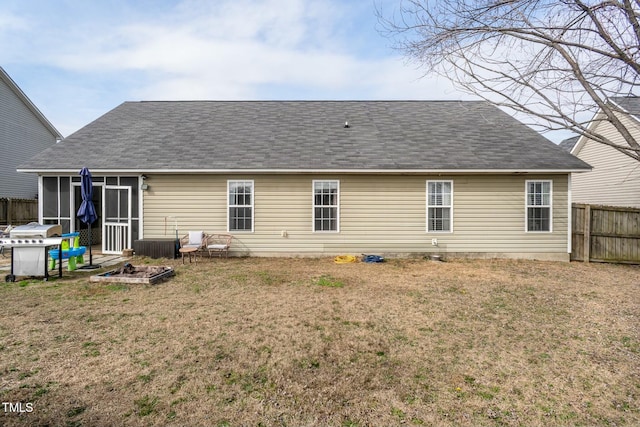 rear view of property with a yard and a sunroom