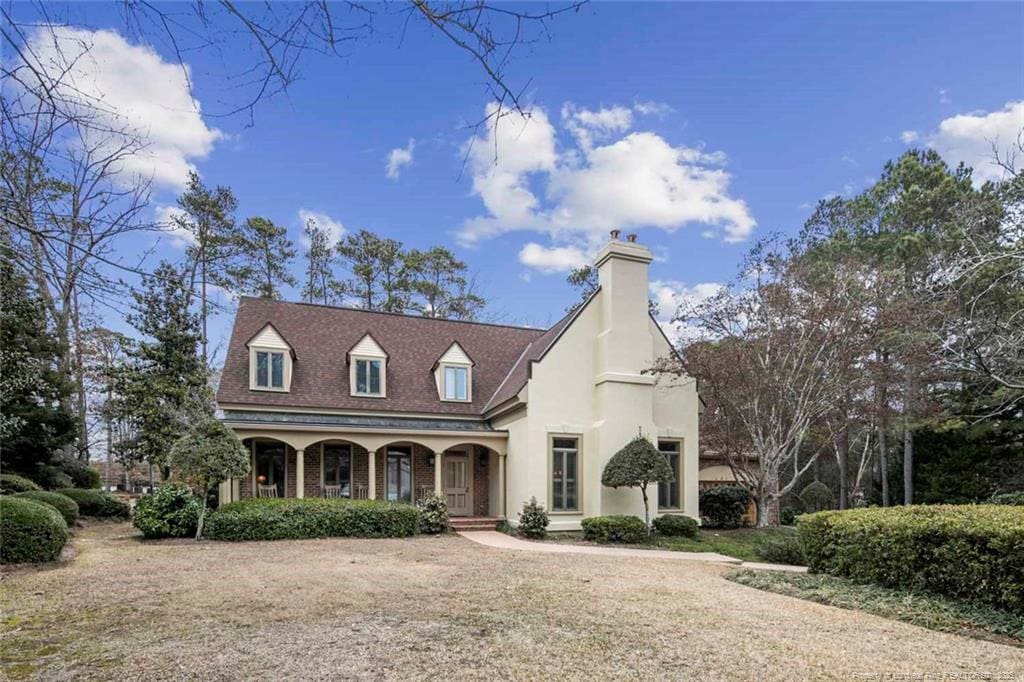 view of front of house with covered porch and a front lawn