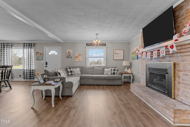 living room with hardwood / wood-style flooring, a fireplace, a healthy amount of sunlight, and crown molding