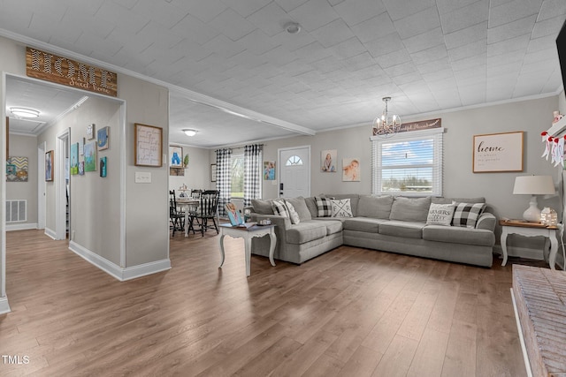 living room featuring hardwood / wood-style flooring, crown molding, and a chandelier