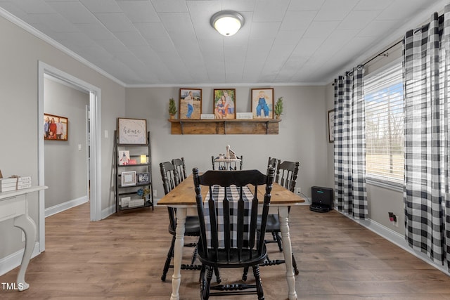 dining room featuring ornamental molding and light hardwood / wood-style floors